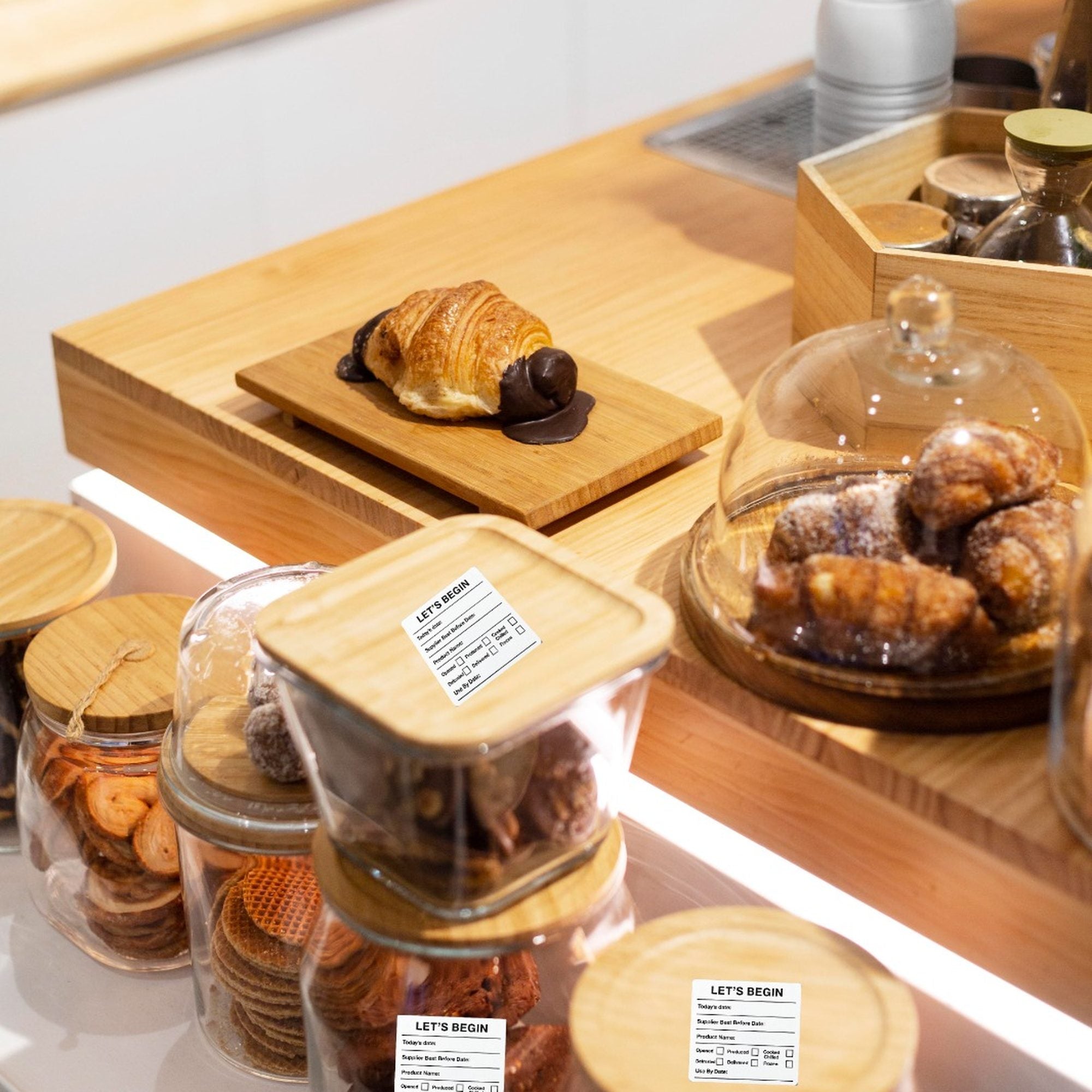 "Waterproof food date label sticker roll"
"Food date labels being applied to container"
"Close-up of easy-peel food date sticker"
"Pack of food date label rolls"
